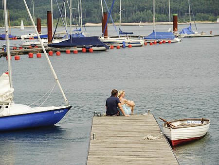 Ein Paar genießt die Zeit an einem Steg des Segelhafens im Seezentrum Ramsberg am Großen Brombachsee