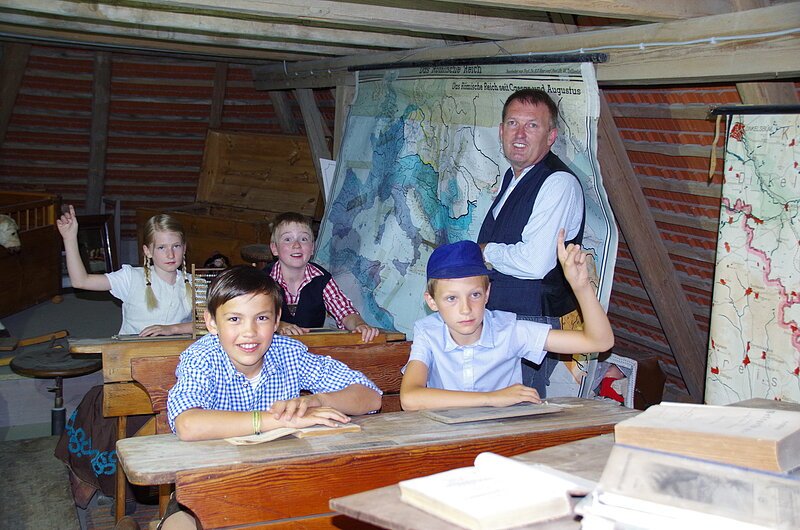 Dorfmuseum Westheim Kinder sitzen in einer alten Schule im Unterricht