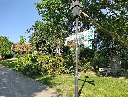 Pfeilwegweiser nach Vorgaben der Forschungsgesellschaft für Straßen- und Verkehrsordnung an einer Laterne in Sausenhofen.