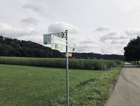 Pfeilwegweiser nach Vorgaben der Forschungsgesellschaft für Straßen- und Verkehrsordnung an einer Pfosten auf dem Radweg bei Treuchtlingen.