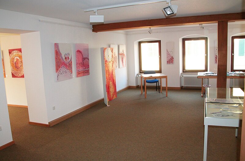 Museum an der Stadtmühle Pappenheim Ausstellung von Bildern und Kunstwerken, die in einem Raum präsentiert werden.