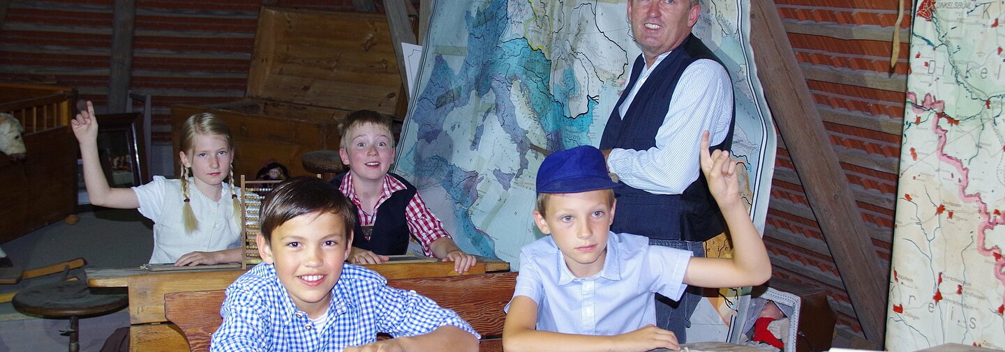 Kinder sitzen in einer alten Schule im Unterricht