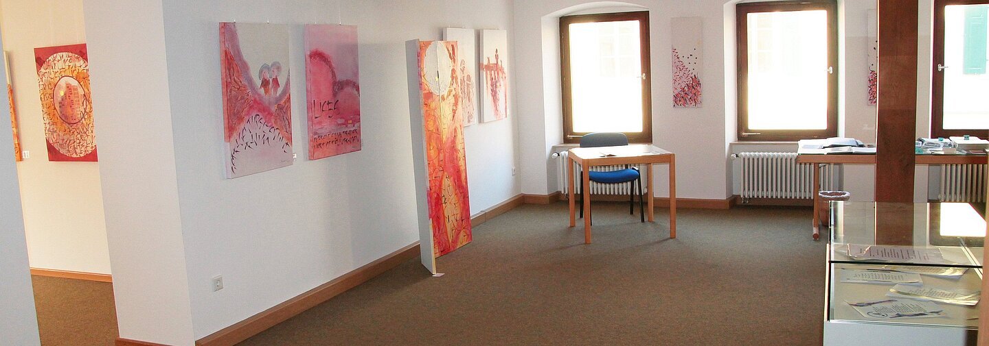 Ausstellung von Bildern und Kunstwerken, die in einem Raum präsentiert werden.