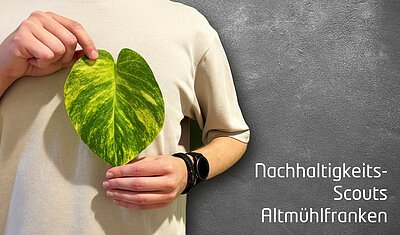 Auf dem Bild sind zwei Hände zu sehen, die ein Blatt in Herzform halten