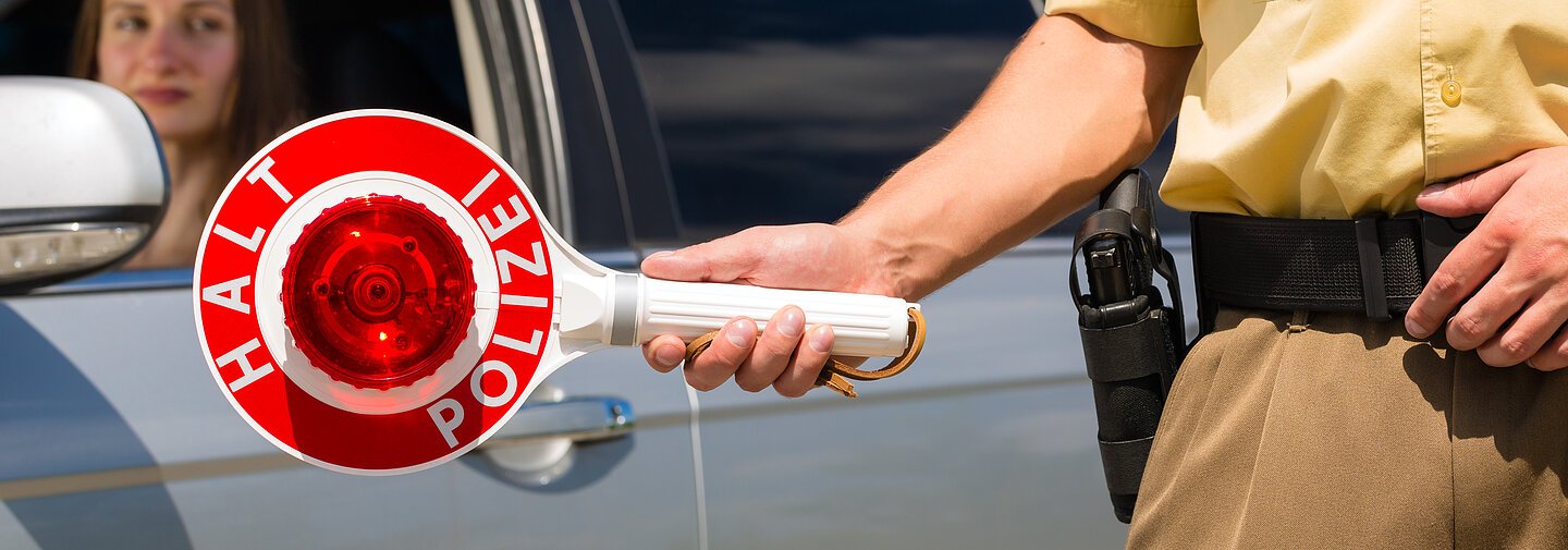 Police - policeman or cop in uniform stop car in traffic control