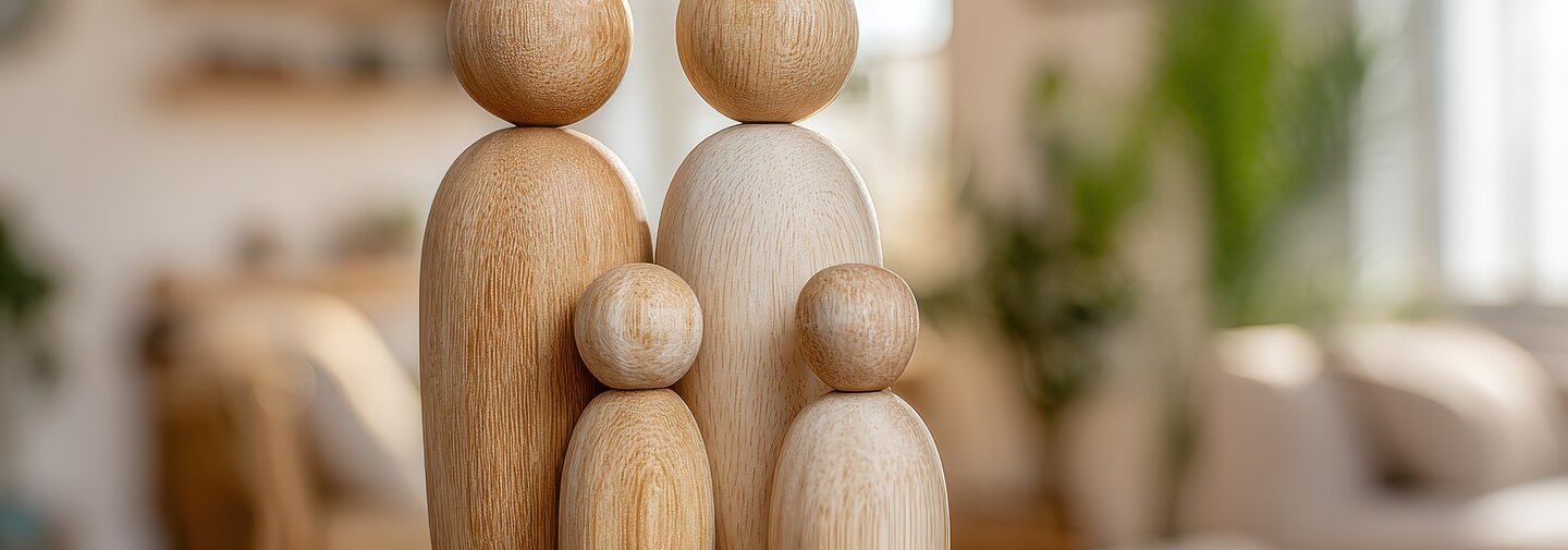 Family with children wooden figures stand together on a blurred living room background. Home ownership and insurance. Conceptual symbolizing protection, relationships and family safety. Harmony symbol